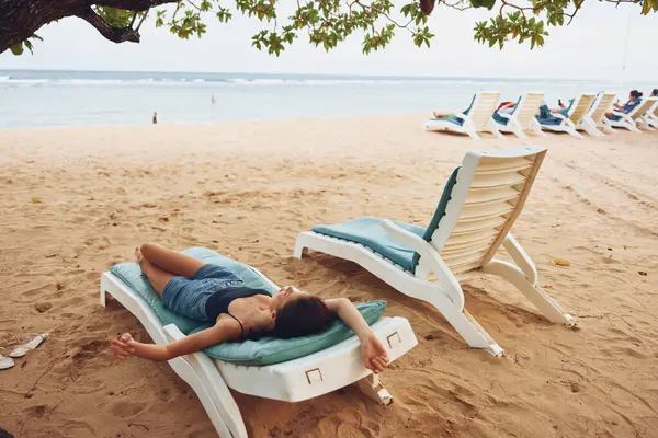 トロピカルレクリエーション休暇 笑顔夏休憩 ビーチリゾート旅行 ライフスタイルに横たわる女性 青い海の太陽のサングラス 太陽の下の海 — ストック写真