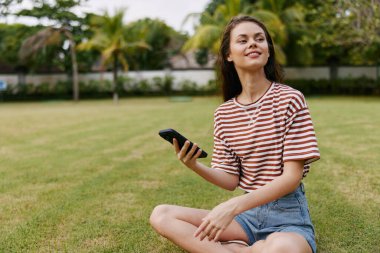 Çimen kadın avuca kadar yürür Kafkas park ağı yaşam tarzı çantası yetişkin telefon ağacı çalışanı blogcu gülen doğa kotu mutlu