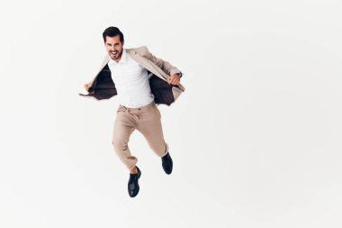 Mutlu uçan adam seksi iş modeli zafer kostümü giyen izole edilmiş bej moda işadamı fikri uçan ceket.