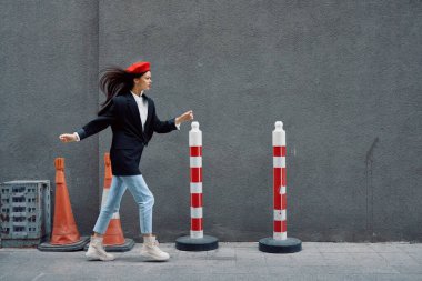 Kırmızı dudaklı, kırmızı bereli, seyahatçi, sinematik renkli, modaya uygun, işe geç kalmış, koşan şehir turistinin önünde koşuşturan modacı kadın. Yüksek kalite fotoğraf
