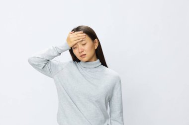 Asyalı bir kadın baş ağrısı ve migren beyazı için elini başına dayadı. Yüksek kalite fotoğraf