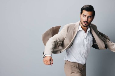 Yetişkin gözlüklü, çekici, kol uçuşu yapan bir adam. Kopya uzay kazanan stüdyo çalışanı, iş adamı. Kendine güvenen bir takım elbise, bej renkli bir el.