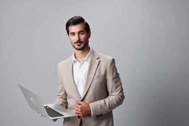 Adam dizüstü bilgisayarı kullanarak online güler yüzlü serbest çalışan internet dijital portresi tecrit edilmiş ofis yöneticisi kopyacı iş adamı stili bej adam
