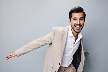 Bej rengi iş adamı gülümsemesi resmi zafer işi mutlu portre kolu fikri kendine güvenen iş adamı gömleği beyaz takım elbisesini kutluyor.