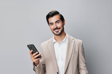 Takım elbiseli adam akıllı telefon teknolojisi gülümsüyor cep telefonlu adam selfie çekiyor izole edilmiş mutlu cep telefonu gri telefon, genç portre erkeği arıyor.