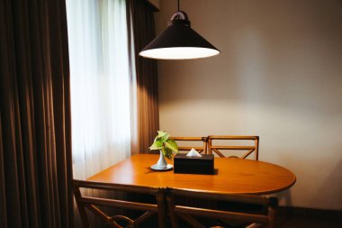 Karanlık evin içi ahşap yemek masası lambayla aydınlatılmış, akşam yemeği için akşam ışığı. Yüksek kalite fotoğraf