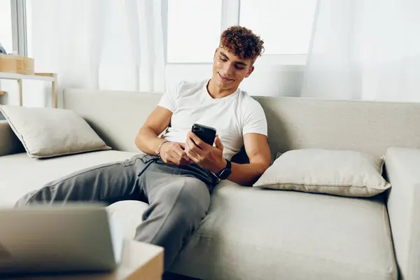 男人室内现代成年人模仿文本智能家庭沙发生活方式坐着交流微笑自由职业者 — 图库照片