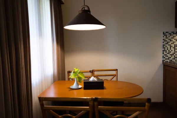 Dark home interior with wood dining table lit by lamp, evening light for dinner. High quality photo