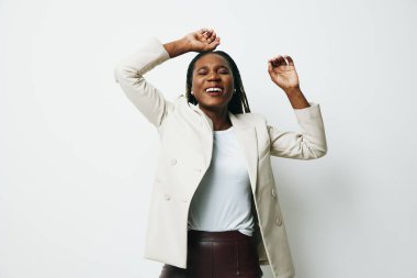 Afro-Amerikan iş kadını portresi. Mutluluk ve gülümseme dansı. İş kıyafetleri ve örgü örgülü ceket. Beyaz arka plan. Yumuşak ve sıcak renkler. - Evet. Yüksek kalite fotoğraf