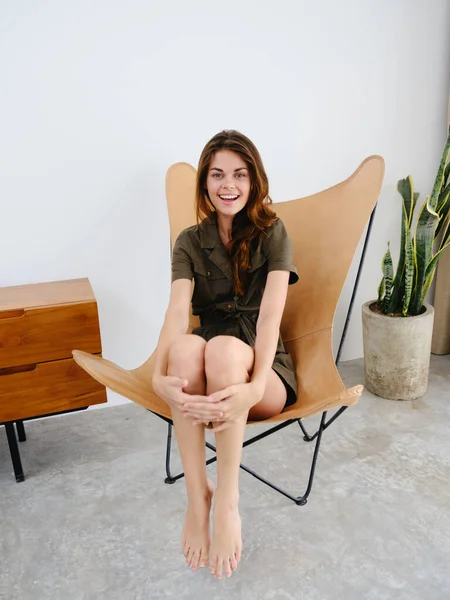Woman model sits on a chair at home smile, fun and relaxation, modern stylish interior scandia lifestyle, copy space. High quality photo