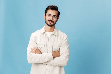 Miyopluk ve hipermetrop için gözlük takan şık bir adamın portresi, beyaz tişörtlü mavi bir arka plan, modaya uygun giyim tarzı, uzay boşluğu. Yüksek kalite fotoğraf