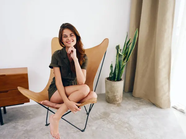 Woman sitting on a chair at home beautiful smile, fun and relaxation, modern stylish interior scandia lifestyle, copy space. High quality photo