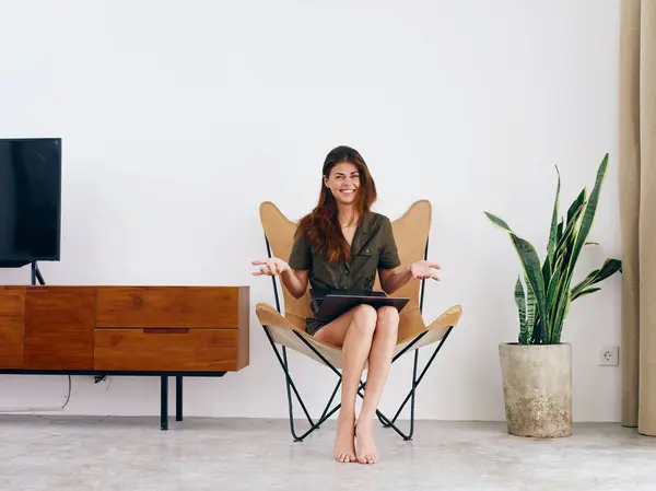 女生学习坐在椅子上 带着笔记本电脑 带着家庭笑容 时髦的斯堪的纳维亚内部生活方式 复制空间 高质量的照片 — 图库照片