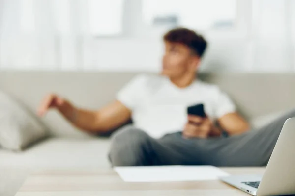 男子室内现代卷曲手机自成幸福的手持者移动沙发细胞生活方式 — 图库照片