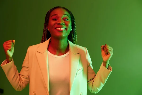 アフリカ系アメリカ人女性の肖像画ビジネス ネオンライトの緑の背景 色の混合されたライト 明るい色の笑顔 ブタを持つ美しいアフリカ系アメリカ人の女性は感情を抱きます 高品質の写真 — ストック写真