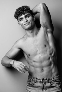 Genç adam spor stüdyosu çekici arka plan siyah güçlü biseps fitness kot pantolon moda şık çıplak trend