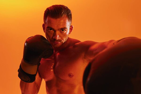 Man bodybuilder boxer muscle workout with naked torso. Advertising, sports, active lifestyle, colored yellow light, competition, challenge concept. . High quality photo