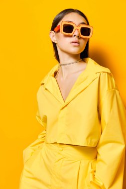 Kafkasyalı genç bir kadın güzel bir stüdyo güzel yaratıcı bir yaşam tarzı moda sarı gözlükler çekici esmer saç stili gülümseme moda tek renkli güzel