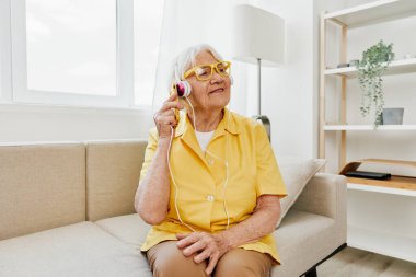 Mutlu, yaşlı bir kadın telefon görüşmeleri gülümsemesini, iletişim teknolojisini, parlak modern iç mekanı, çevrimiçi yaşam tarzını araştırıyor. Yüksek kalite fotoğraf