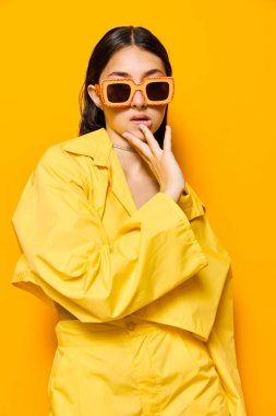 Hayat tarzı bir kadın güzel bir jest duygu genç tarz bir arka plan güneş gözlükleri neşeli sarı moda moda moda bayan tek renkli moda çekici kız çekici dans