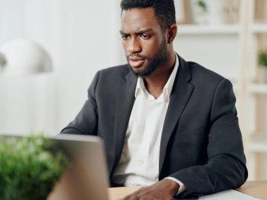 Serbest çalışan Amerikan İletişim Ofisi Bilgisayarı Amerikalı genç erkek eğitim müdürü laptop Afrikalı siyahi iş adamı gülümseyen serbest çalışan