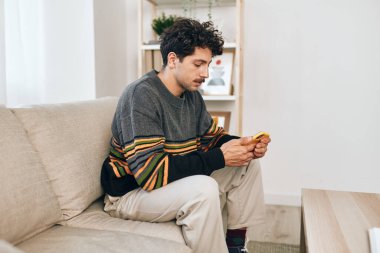 Kanepe adamı teknoloji evi Kafkasyalı akıllı telefon telefon beyaz kanepe iletişim yaşam tarzı bağlantı mesajı erkek yazıcı evde rahatla dijital serbest çalışma odası