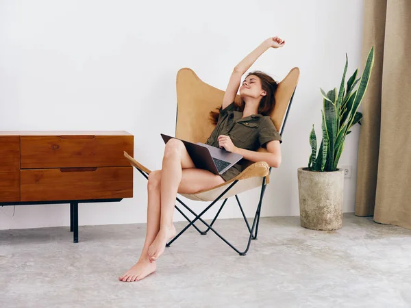 自由职业女学生坐在椅子上 带着笔记本电脑在家里工作 笑着放松一下 现代时髦的斯堪的纳维亚内部生活方式 复制空间 高质量的照片 — 图库照片
