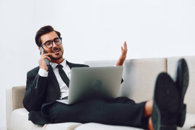 Profesyonel mesleki işgal ofisi bilgisayarı başarılı iletişim dizüstü bilgisayarı İnternet konuşması gülümseme telefon çekici iş telefonu kazananı kanepe videosu yetişkin telefonu