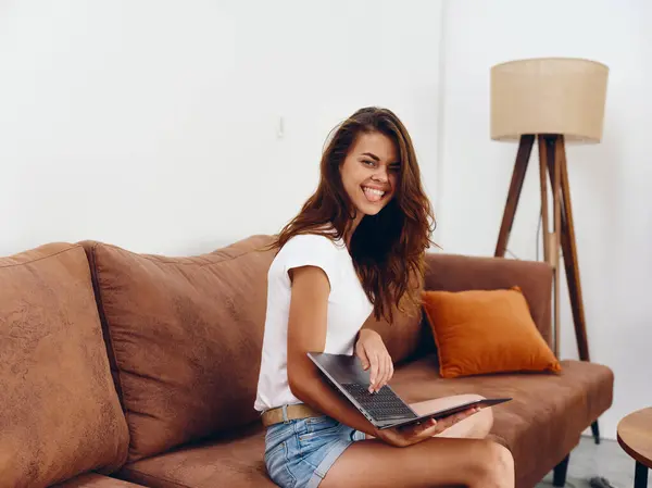 女自由撰稿人坐在沙发上 带着笔记本电脑般美丽的笑容 时髦的斯堪的纳维亚内部生活方式 复制空间 高质量的照片 — 图库照片