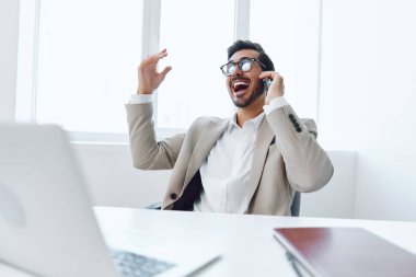 Genç ofis teknolojisini belgeleyen mutlu bilgisayar kazananı yetişkin telefon işadamı kablosuz çekici video konuşma gülümseme başarı iletişim iletişim portresi iş yeri