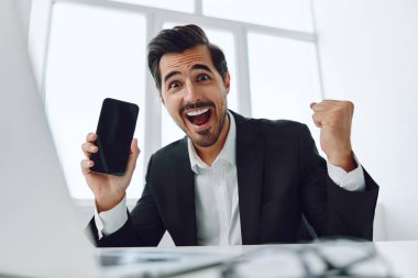 Kazanan ofis genç çekici yönetici cep telefonu bilgisayar mutlu erkek işgalci gülümseme telefon kablosuz iş adamı akıllı