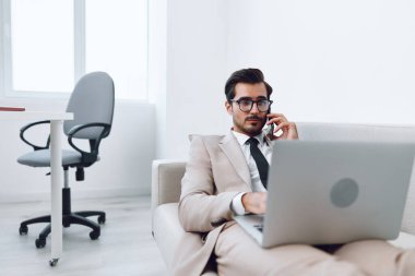 Cep telefonlu genç işadamı takım elbisesi Kafkasyalı akıllı telefon laptop video telefon portresi kazanan ofis cep telefonu konuşma bilgisayar gülümsemesi başarısı