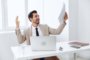 Erkek doküman dizüstü bilgisayar firması başarılı bir iş adamı başarılı bir teknoloji kağıt planlama olumlu ofis uzmanlığı mutlu gülümseme