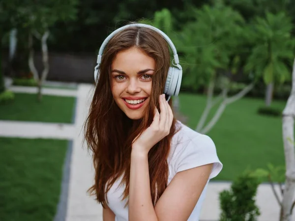 Portrait of a woman wearing headphones close-up smile with teeth flying hair, tropical tan. High quality photo