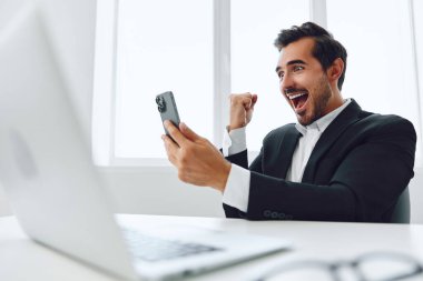 Ofis işadamı masasında oturuyor ve dizüstü bilgisayarda çalışıyor ve telefonla konuşuyor, modern takım elbise, finans ve başlangıç konsepti ve veri analizi, parlak bir ofiste çalışma tarzı. Yüksek kalite fotoğraf