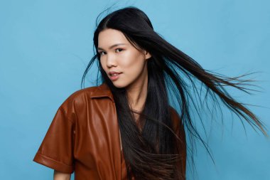 Kadın yaşam tarzı modayı takip eden neşeli saçlı bayan stüdyo işi gülümseme güzellik moda çekici Asyalı mavi arka plan kızı uzun Japon özgüvenli Koreli şirin portre