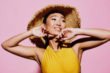 Dudakları kadın Asyalı güzel sarı el modeli mutlu mutlu pembe moda yaz modasına uygun bir mayo gülümsemesi sıradan portre gözleri