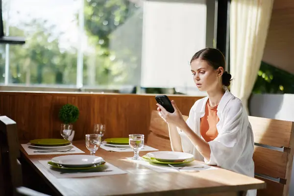 Mobile person smiling meal phone cafe smartphone young adult communication technology female lifestyle work lunch sitting caucasian women table food restaurant eating happy business
