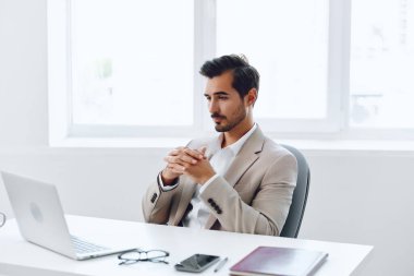 Ofis işadamı masasında oturuyor ve dizüstü bilgisayarda çalışıyor ve telefonla konuşuyor, modern takım elbise, finans ve başlangıç konsepti ve veri analizi, parlak bir ofiste çalışma tarzı. Yüksek kalite fotoğraf