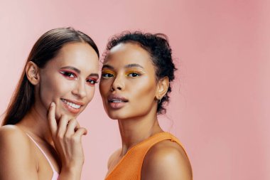 İki sağlıklı güzel makyaj yüzü birlikte pembe ırk Afrikalı çekici kızlar mutlu mutlu renkli Amerikan güzellik modeli vücut bakımı stüdyo portresi
