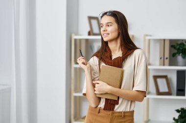 Kapalı alan kadın kalem sınavı planlama, not defteri öğrenci işi ofis çalışması, üniversite geçmişi, gülümseyen günlük.