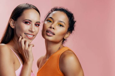 Kız kadın yarış modeli güzel Afrikalı portresi birlikte parlıyor pembe renkli ten stüdyosu mutlu karışık güzellik makyajı iki çekici yüz