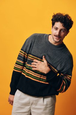Yaşam tarzı genç duygu portresi öğrenci stüdyosu gündelik İspanyol moda gülümsemesi mutlu turuncu erkek arka plan süveter sarı moda kış sakalı beyaz