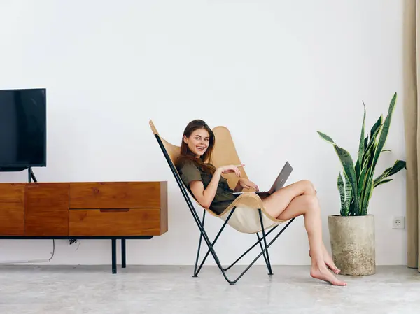 女生学习坐在椅子上 带着笔记本电脑 带着家庭笑容 时髦的斯堪的纳维亚内部生活方式 复制空间 高质量的照片 — 图库照片