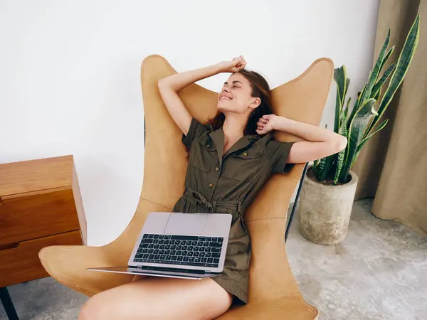 女人坐在椅子上 带着笔记本电脑在家里美丽的微笑和放松 时髦的斯堪的纳维亚内部生活方式 复制空间 高质量的照片 — 图库照片