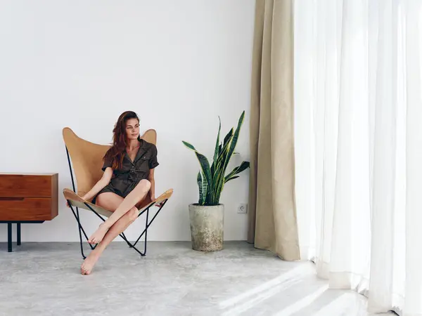 Mujer Sentada Una Silla Cerca Ventana Sonriente Interior Moderno Elegante — Foto de Stock