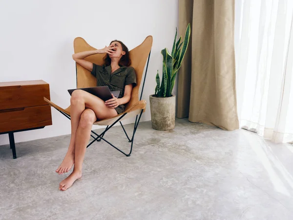 フリーランスの女性は 自宅でラップトップワークと椅子に座って眠っている モダンなスタイリッシュなインテリアスカンジナビアのライフスタイル コピースペース 高品質の写真 — ストック写真