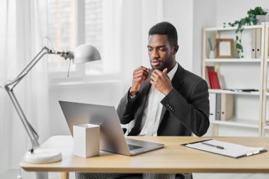 Serbest çalışan bir adam. Ev masası boş. Afrikalı bir öğrenci dizüstü bilgisayar masası. Çevrimiçi iş konferansı, ofis eğitimi.