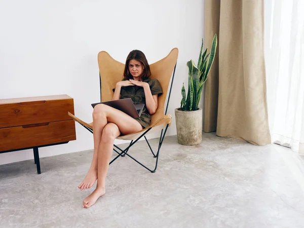 女自由撰稿人坐在椅子上 带着笔记本电脑工作在家里怒气冲冲 时髦的斯堪的纳维亚内部生活方式 复制空间 高质量的照片 — 图库照片