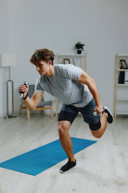 Erkekler spor kıyafetlerini, spor kıyafetlerini, spor salondaki halterleri, gri yaşam tarzı dizüstü bilgisayarları, ev yapımı spor kaslarını, spor karın kaslarını seyreder.